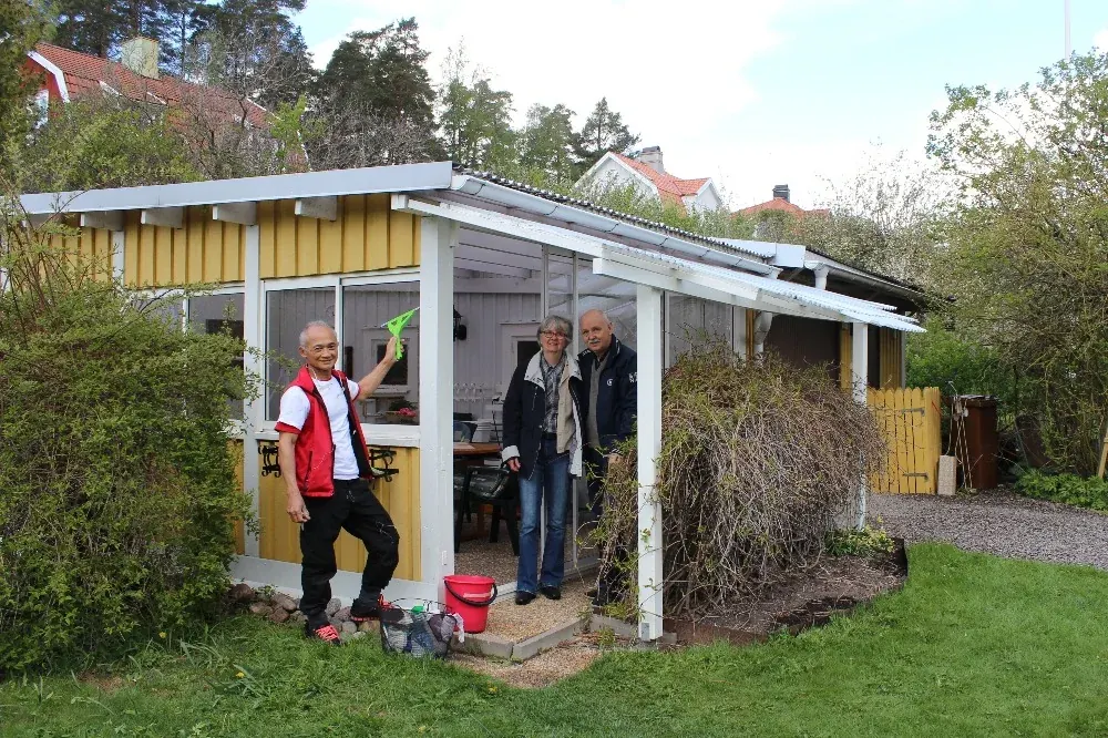 Medarbetare putsar rutor i ett lusthus medan kunderna ser på
